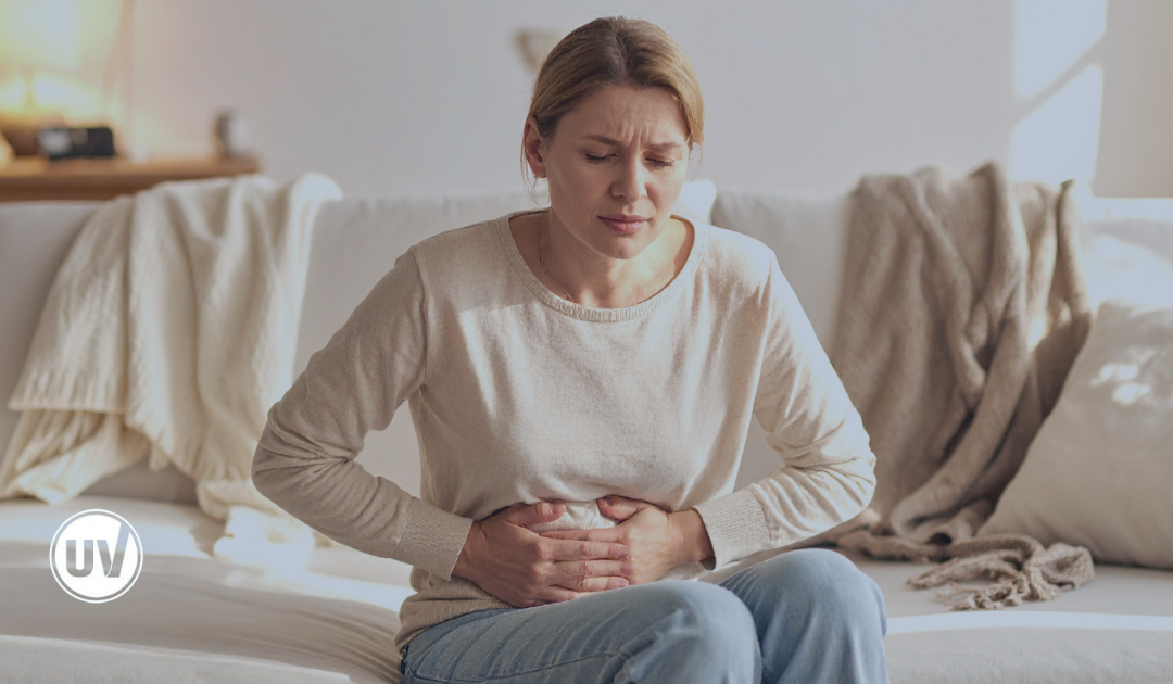 Woman with abdominal pain holding her stomach, illustrating symptoms of irregular periods and potential uterine health issues.